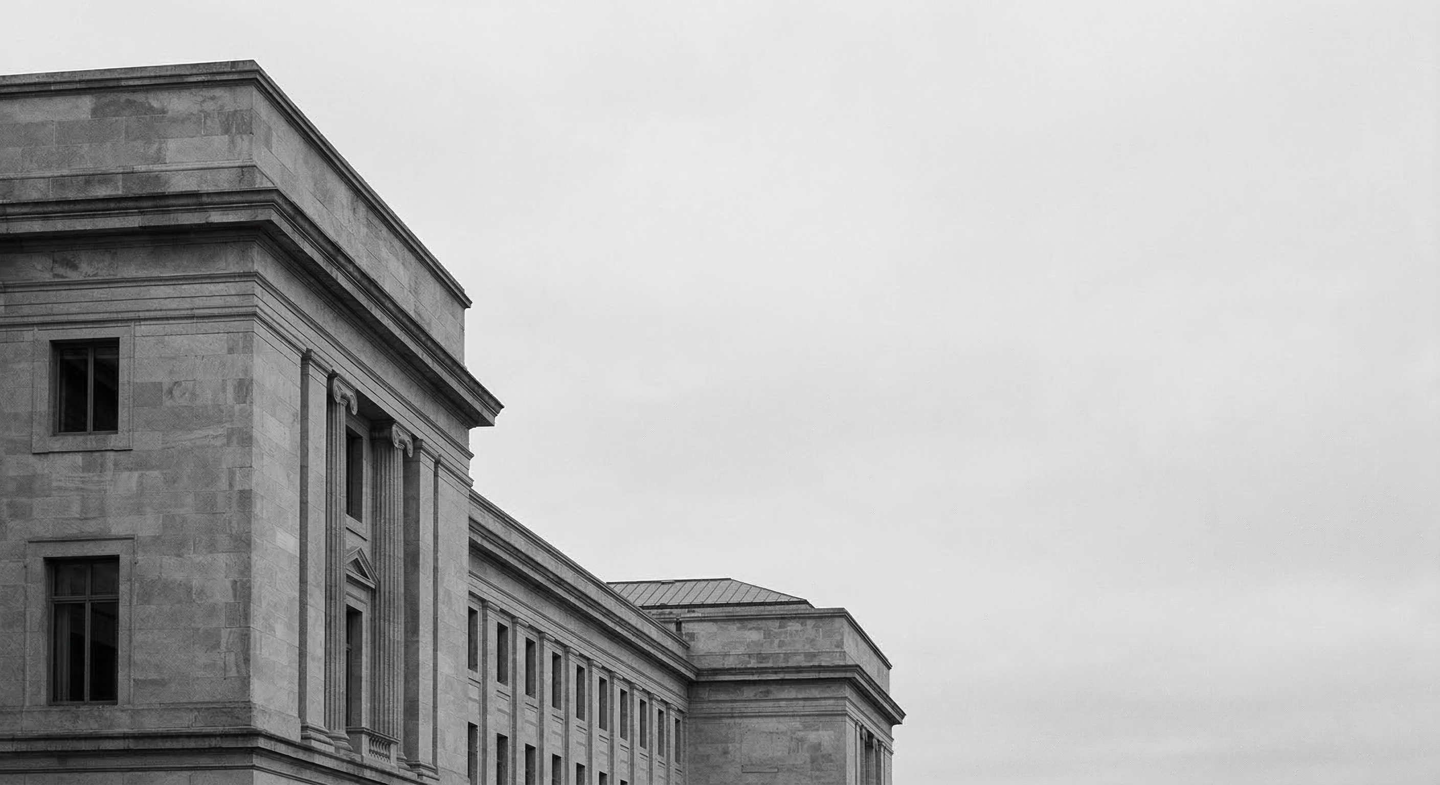 Monochrome institutional building beneath an overcast sky